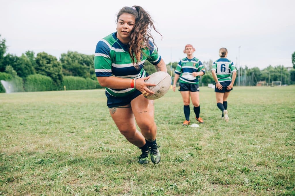Focused rugby player running with the ball during a match Focused rugby player running with the ball during a match