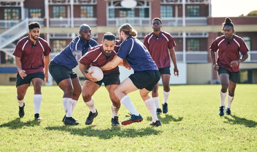 Rugby, fitness and tackle with a team on a field together for a game or match in preparation of a c