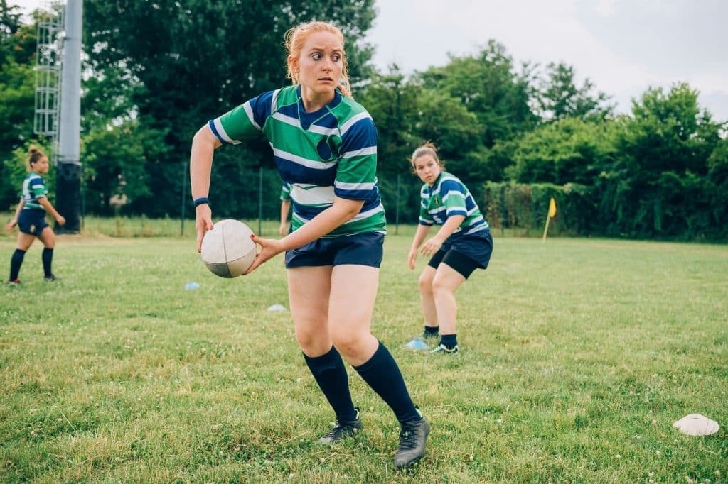Rugby player in focus ready to pass the ball during a game Rugby player in focus ready to pass the ball during a game